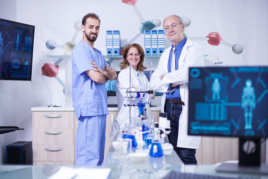 Smiling scientist colleagues in their uniform standing in chimical lab