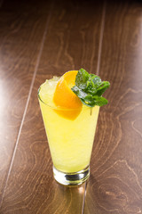 Orange Lemonade with crushed ice in tall glass on wooden table