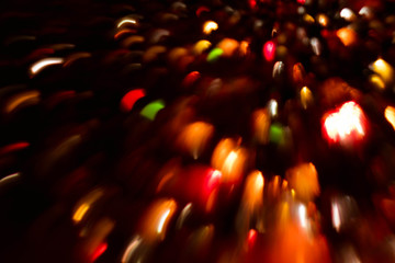 Blur red and orange fairy lights. Multicolor smeared glowing spots. Dark abstract background.