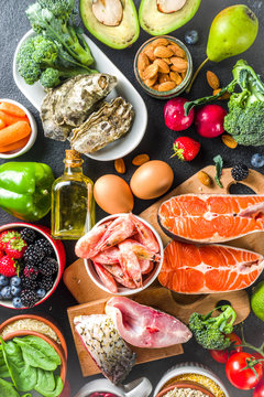 Pescetarian diet plan ingredients, healthy balanced grocery food, fresh fruit, berries, fish and shellfish clams,  black background copy space 
