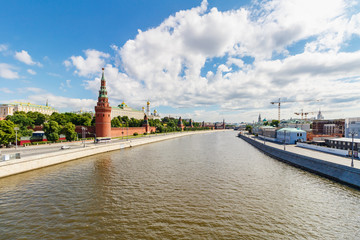Obraz premium Embankments of Moskva river on a background of Moscow Kremlin in sunny summer morning against blue sky with white clouds