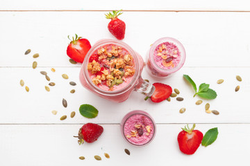 Strawberry with yogurt on white rustic wooden background. Cream dessert