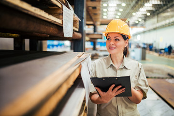 Portrait of a beautiful female worker at the factory warehouse.
