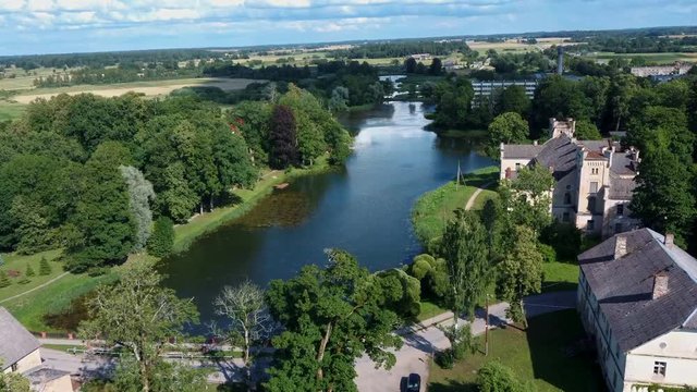 Aerial Dron Shot of the Cirava Lutheran Church Aizpute  Latvia, Sunny Summer Day. Flaying Above the  Church and Manor Castle.