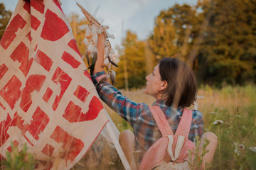 hipster woman in the form of a Shaman is looking for inspiration from mother Earth in a wigwam in...