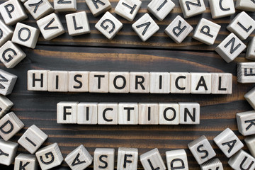 historical fiction - word from wooden blocks with letters, Literary Genres concept, random letters around, top view on wooden background