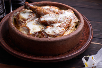 Chkmeruli chicken on a dark background on a wooden board