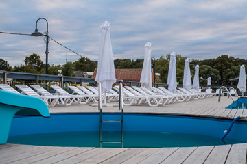 Obraz premium Hotel lounge area with swimming pool and sun loungers