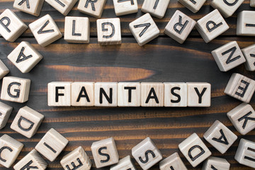 fantasy - word from wooden blocks with letters, Literary Genres concept, random letters around, top...