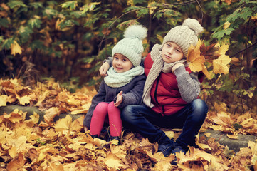 Children in warm clothes for a walk in the autumn Park