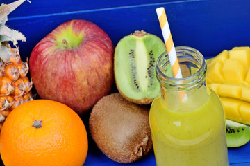 Glass of juice with fruit mix on wooden table