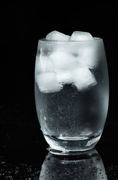 verre d'eau avec glacon sur fond noir