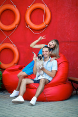 guy and the girl with the pug are resting on beanbag chair