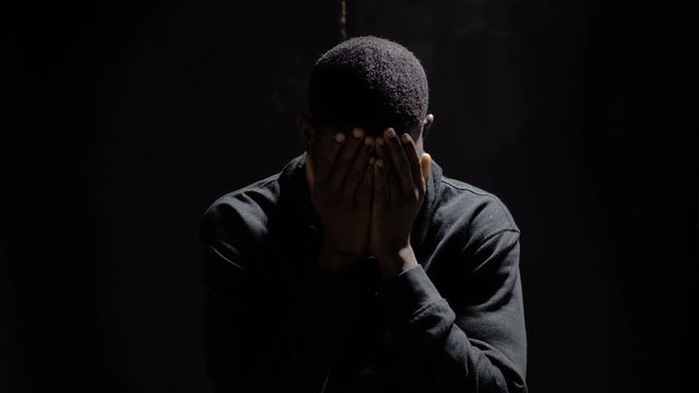 Desperate sad young black african migrant  in the darkness.Desperation,migration