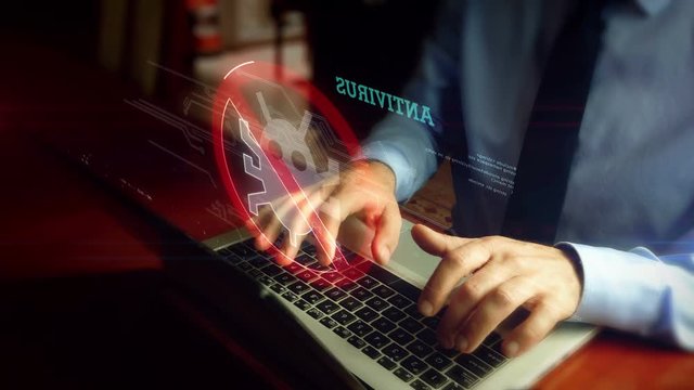 Man in tie is typing on laptop with antivirus hologram screen over keyboard. Computer protection, cyber security and internet safety concept. Natural hand camera shake.