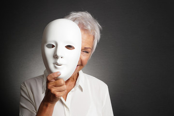 happy smiling laughing senior woman peeking from behind mask