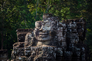 Ancient face stone temple in ruins close the jungle