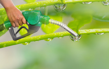 Green conservation. Gas pump nozzle and leaf background. Fuel dispenser on nature background....