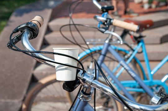 Kyiv, Ukraine - June 27, 2019: Girls' Bike Show-KYIV CYCLE CHIC. Close-up of a paper cup with water attached on a bicycle.