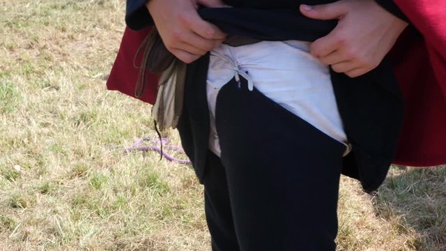 Medieval Reenactor Adjusting Historical Costume Armor Clothing at Reenactment Festival