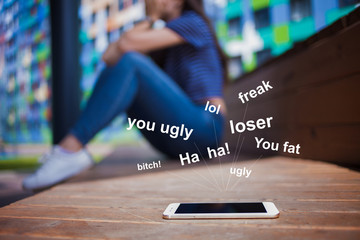 A smartphone lying in the foreground, blurred background, girl, crying, covering face while sitting...