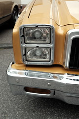 Doppelscheinwerfer mit Chrom und Glanz eines Luxus Pick-up der Siebziger Jahre in Gold Metallic aus...