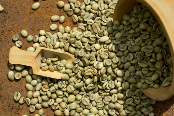 green coffee beans in wooden bowl