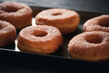 Donuts with sugar on a tray in a bar