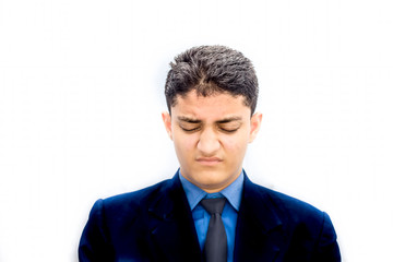 Portrait shot of a businessman wearing a blue colored suit with a black necktie with sad and losers like the expression on his face feeling laziness and sleepiness.