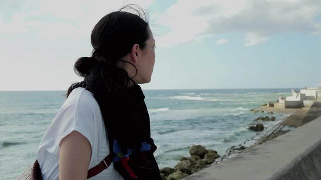 Woman standing on beach, Chatan, Okinawa Prefecture, Japan
