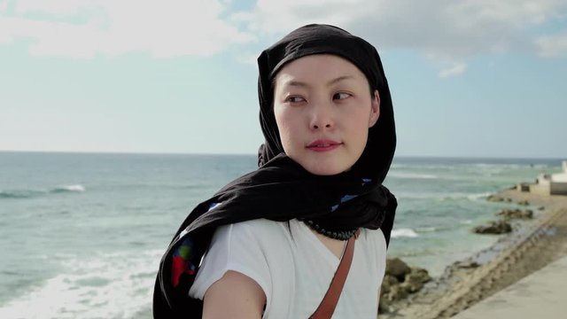 Woman standing on beach, Chatan, Okinawa Prefecture, Japan