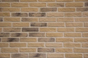 light brown stone brick exterior wall in hard light emphasizing stone's textures and depth