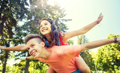 holidays, vacation, love and people concept - happy smiling teenage couple having fun at summer park