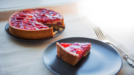Sweet dessert with strawberries, cheesecake cake with slices of berries in jelly on top.
