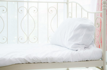 The white bed is in the sun-warmed bedroom in the morning. White bedroom in the morning.Do not focus on objects.