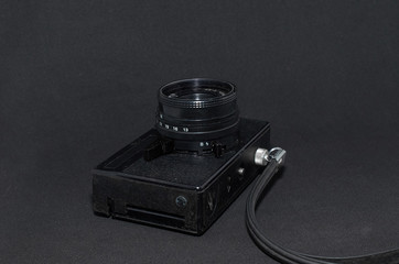 old film camera with strap close-up on a black background