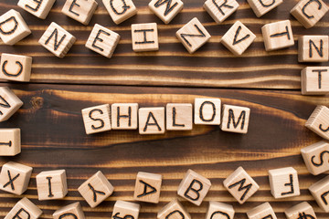 Shalom - word from wooden blocks with letters, Jewish greeting or saying goodbye concept, random...
