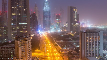 Dubai downtown skyline night to day aerial timelapse with traffic on highway