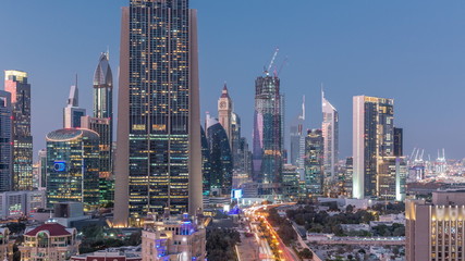 Fototapeta na wymiar Skyline view of the buildings of Sheikh Zayed Road and DIFC day to night timelapse in Dubai, UAE.