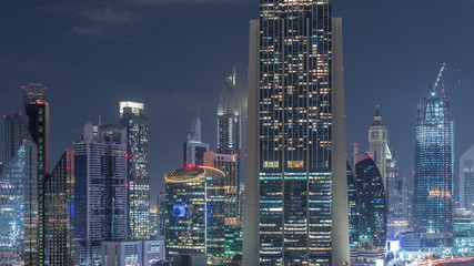 Aerial view on downtown and financial district in Dubai night timelapse, United Arab Emirates with skyscrapers and highways.