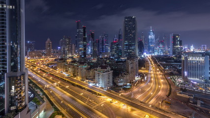 Aerial view on downtown and financial district in Dubai during all night timelapse, United Arab Emirates with skyscrapers and highways.