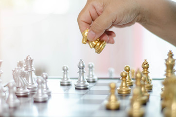 An Asian old woman wears a blue shirt and a friend is playing a chess game.