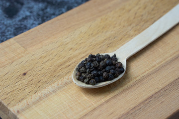 Fototapeta na wymiar Black pepper on wooden spoon.
