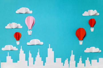 Hot air balloons paper cut objects in the sky above city skyline. Craft paper objects photography...