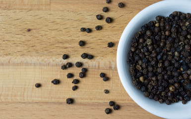 Fototapeta na wymiar Black pepper in a bowl on wooden background.