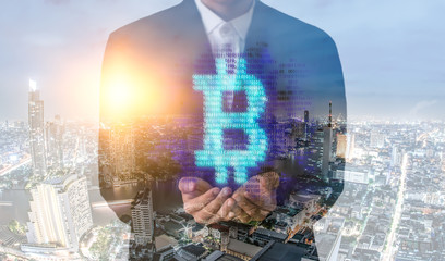 Double exposure image of Businessman hand holding bitcoin digital hologram and internet of things on city background.making money with bitcoin - Business man creating bitcoins with his hand.