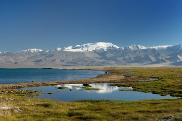 Fototapeta na wymiar The beautiful Karakul lake by the Pamir highway. View on the lake and Peak Lenin near Karakul village in the Pamirs, Tajikistan, Central Asia