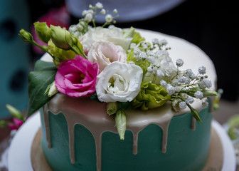 The cake is decorated with fresh flowers. Beautiful and stylish wedding cake