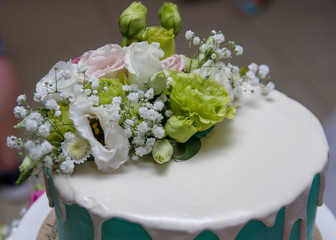 The cake is decorated with fresh flowers. Beautiful and stylish wedding cake