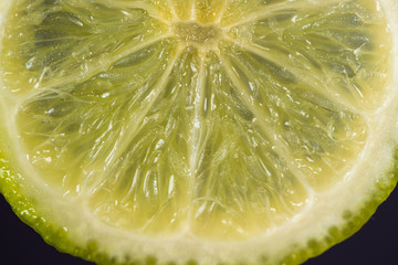 Closeup macro photo of lime sliced on dark background freshly sliced green lime front view.
